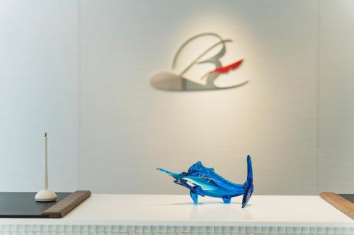 a blue figurine on a table in front of a wall at Rembrandt Style Naha in Naha