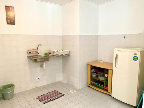 a kitchen with a sink and a refrigerator at BayView Suites Port Dickson By MAISON in Port Dickson