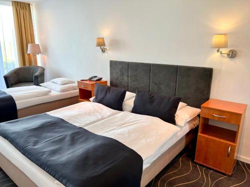 a hotel room with two beds and a chair at Holiday Resorts in Balatonszárszó
