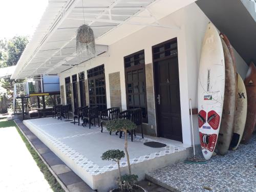 a building with a surfboard on the side of it at Manuh Guest House in Nusa Dua