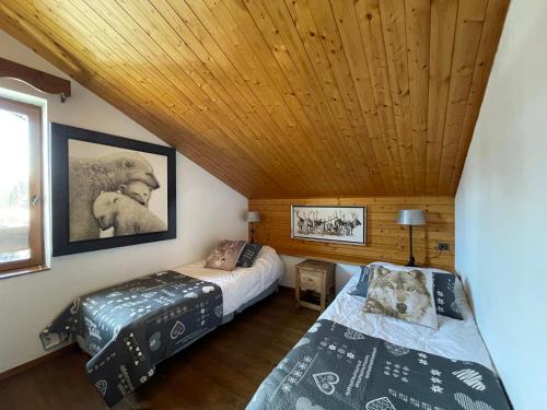 a bedroom with two beds and a wooden ceiling at Club Alpina - Champagny-en-Vanoise in Champagny-en-Vanoise