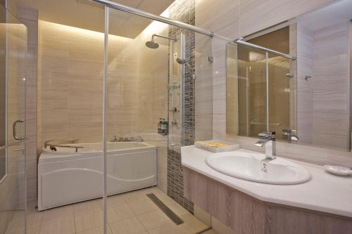 a bathroom with a sink and a tub and a shower at Renyi Lake Hotel in Fanlu