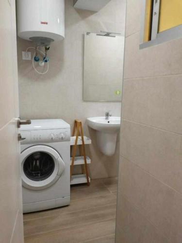 a bathroom with a washing machine and a sink at KubiK APARTAMENTOS K1 in Cáceres