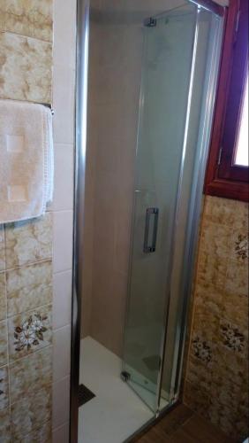 a shower with a glass door in a bathroom at Es Jaç in Cala Santanyi