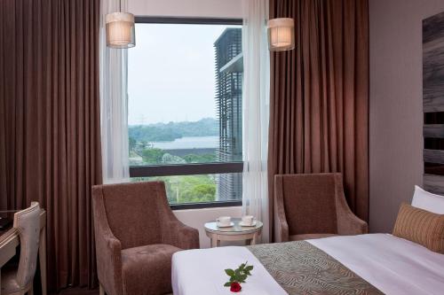 a hotel room with a bed and two chairs and a window at Renyi Lake Hotel in Fanlu