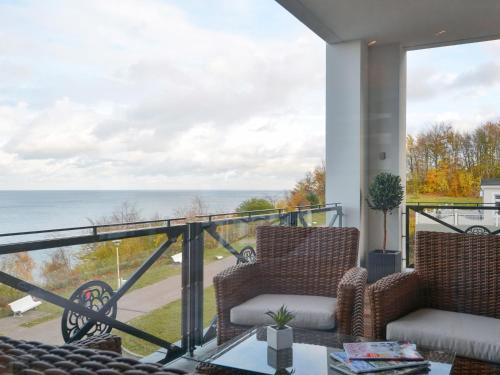 a balcony with two chairs and a view of the ocean at Villa Claire - Meerblicksuite "Sunrise Queen" in Ostseebad Sellin