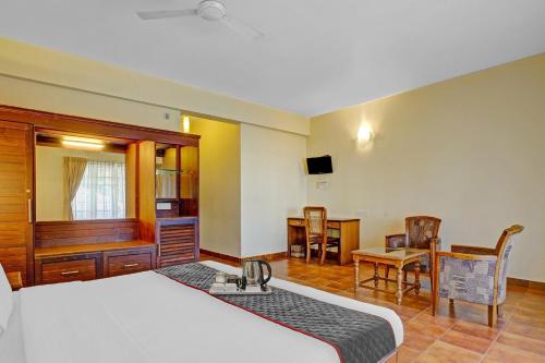 a bedroom with a bed and a desk and a table at The Fort Manor Hotel - Kochi Kerala in Fort Kochi
