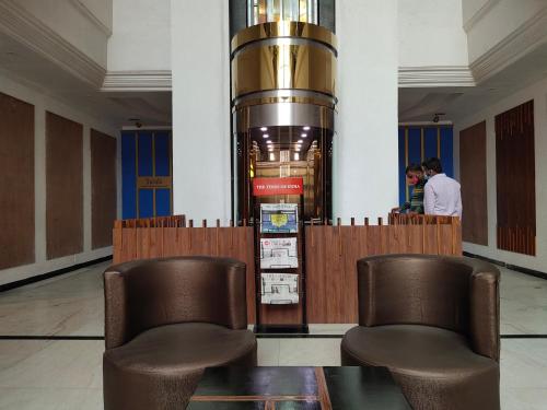 two chairs and a table in a lobby at Zip By Spree Hotels Surabi International Vellore in Vellore