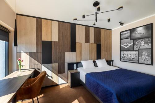 sypialnia z łóżkiem i biurkiem z niebieskim kocem w obiekcie Hotel Kozerki w mieście Kozerki