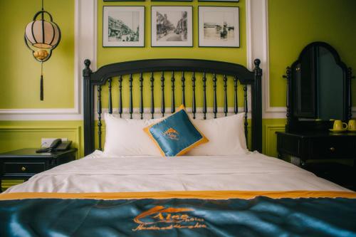 a bedroom with a large bed with green walls at Alee Haiphong Hotel in Hai Phong
