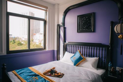 a girl laying on a bed in a purple bedroom at Alee Haiphong Hotel in Hai Phong