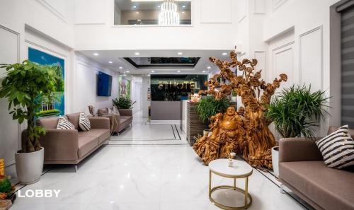 a lobby with couches and a tree in the middle at 3T Hotel Hanoi in Hanoi