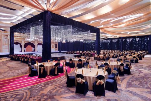 a group of people sitting at tables in a banquet hall at Grand Mercure Malang in Malang