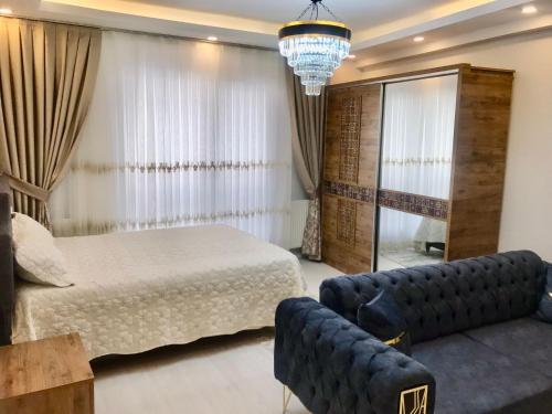 a bedroom with a bed and a couch at L'élégance de JJM in Esenyurt