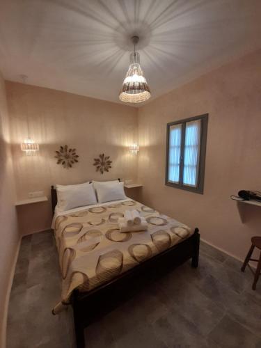 a bedroom with a large bed and a chandelier at Studios Kapsali in Galini