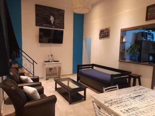 a living room with a couch and a table at Hermosa casa con patio, parrilla y garage cerrado in Tandil