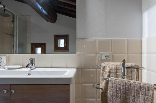 a bathroom with a sink and a mirror and towels at Villa Montegemoli - by Bolgheri Holiday in Pomarance
