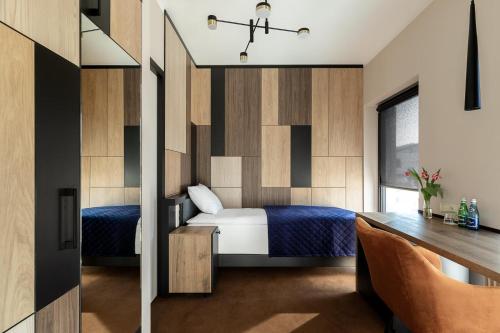 a bedroom with a bed and a desk at Hotel Kozerki in Kozerki