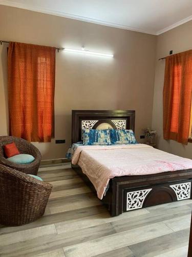 a bedroom with a large bed and a chair at Nature Villa in Haldwāni