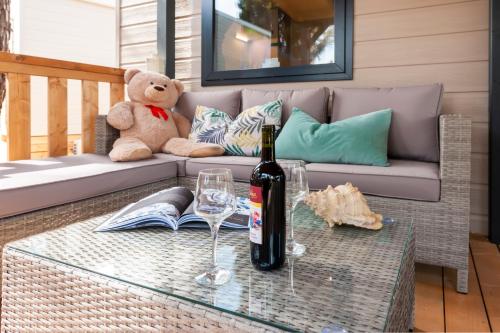 a bottle of wine and a teddy bear on a couch at Glamping and Mobile Homes Lavanda - Holiday Centre Bi VIllage in Fažana