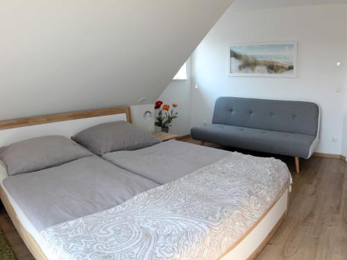 オストゼーバート・カールスハーゲンにあるFerienhaus Aurin AURIのベッドルーム1室(ベッド1台、青い椅子付)