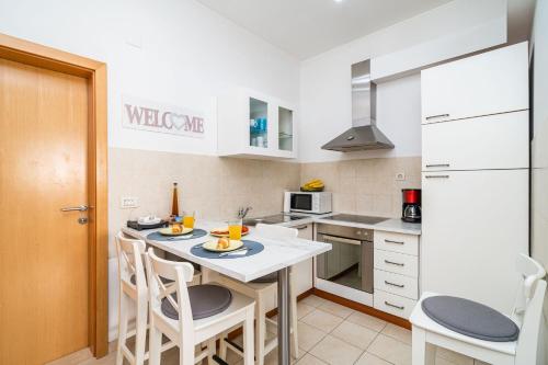 a kitchen with a counter with chairs and a table at Apartment Larissa in Dubrovnik