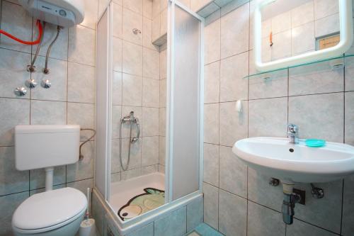 a small bathroom with a toilet and a sink at Apartmani Branka in Rtina