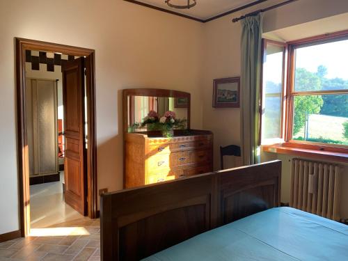a bedroom with a dresser and a mirror at B&B ABBAZIA Sant'ELENA in Serra San Quirico