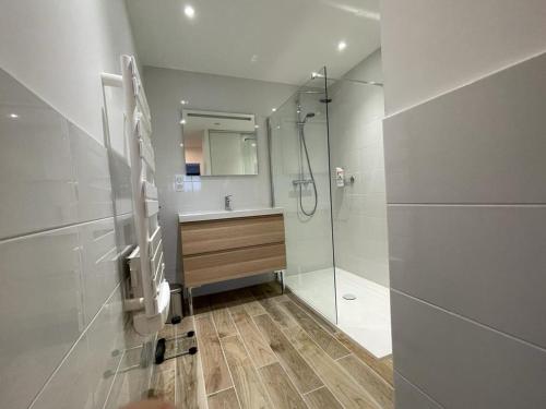 a bathroom with a shower and a sink and a mirror at Maison contemporaine aux portes de Brest in Bohars