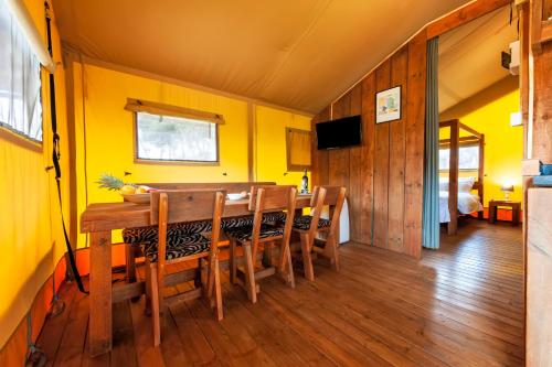 a dining room with yellow walls and a table and chairs at Glamping and Mobile Homes Lavanda - Holiday Centre Bi VIllage in Fažana