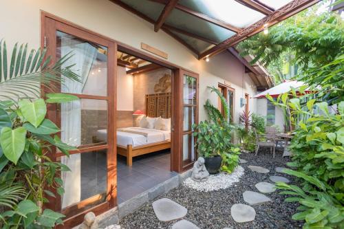 a room with a bed in the middle of a garden at Villa SoDe Balangan by Nagisa Bali in Jimbaran