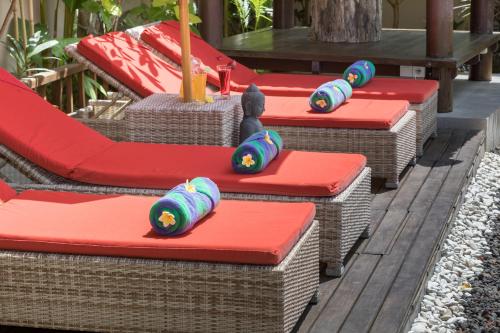 a row of wicker chairs with colorful hats on them at Villa SoDe Balangan by Nagisa Bali in Jimbaran