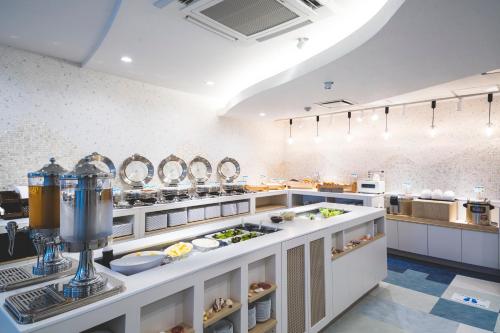 a large kitchen with a counter with food at Rembrandt Style Naha in Naha