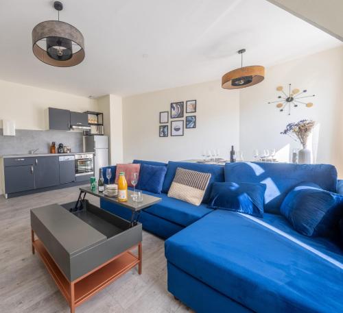 niebieską kanapę w salonie z kuchnią w obiekcie Les Appartements de la Nef d'Or w mieście Saint-Quentin