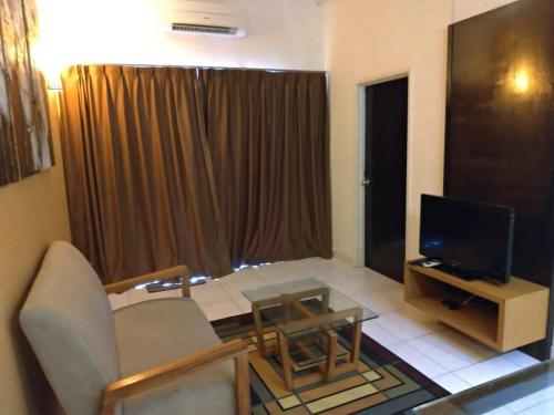 a living room with a couch and a television at Beach View @ Morib Gold Coast in Banting