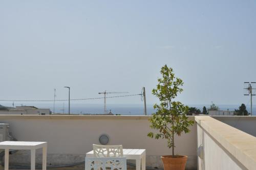 a balcony with a table and a tree on a building at Mimi Leuca B&b in Leuca