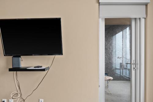 a flat screen tv hanging on a wall at Stylish Downtown Condos by GLOBALSTAY in Calgary