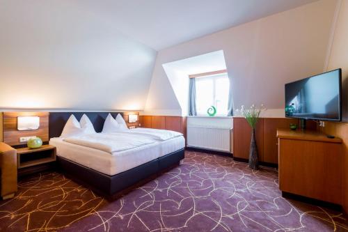 a bedroom with a bed and a flat screen tv at Gasthaus Wundsam in Neustift im Mühlkreis