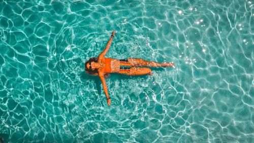 a woman laying in the water in a pool at CONNECT THERMAL HOTEL in Ankara