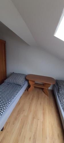 een kamer met 2 bedden en een houten tafel bij Agroturystyka u Wiesi in Cięcina