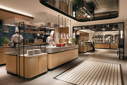 a restaurant kitchen with a chef in the middle at Hilton Singapore Orchard in Singapore