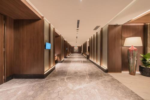 a hallway of a building with wooden walls and a long corridor at Ashley Tanah Abang in Jakarta