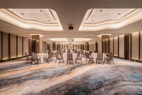 a banquet hall with white tables and chairs at Ashley Tanah Abang in Jakarta