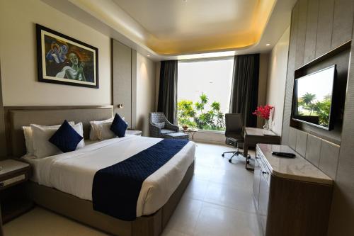 a hotel room with a large bed and a window at Stardom Resort Jaipur in Jaipur