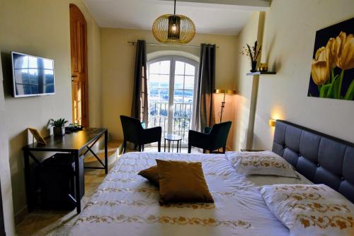 a bedroom with a bed and a desk and a window at Chambre d'hôtes Cottes in Callian