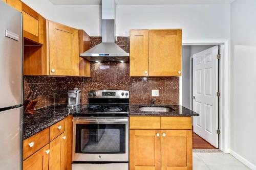 a kitchen with wooden cabinets and a stove top oven at The blue wall 2BD apartment with excellent location in Philadelphia
