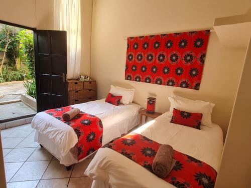 Un dormitorio con dos camas y un cuadro en la pared. en Planet Scuba Bed and Breakfast, en Ponta do Ouro