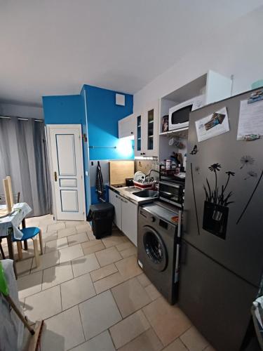 une cuisine avec un réfrigérateur et une machine à laver dans l'établissement Les pieds dans l'eau, à Grimaud