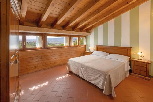 a bedroom with a bed in a room with windows at Agriturismo Casa Rosa in Verona