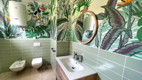 bagno con servizi igienici, lavandino e specchi. di Leaf Apartment a Ravenna